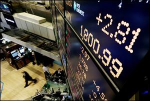 A board above New York Stock Exchange’s trading floor shows the Standard & Poor’s 500 index crossing the 1,800 threshold Monday.