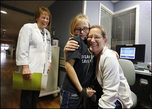 Allison Herr, 10, of Metamora, Ohio, hugs nurse Debbie Martin in the neonatal intensive care unit at Mercy St. Vincent Medical Center as Donna Ruedisueli, director of women's and children's services, looks on. 