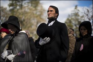 John Voehl portraying President Abraham Lincoln,  covers his heart during a ceremony commemorating the 150th anniversary of the dedication of the Soldiers’ National Cemetery and President Abraham Lincoln's Gettysburg Address, Tuesday.