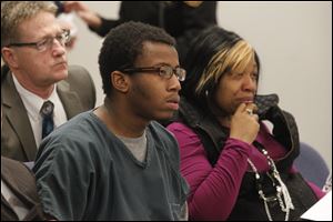 Kei'ron Toyer, 17, left, sits with his mother Ebony Toyer, right, during his sentence for delinquency in the commission of a rape of a 15-year-old Sylvania girl in Lucas County Juvenile Court today.