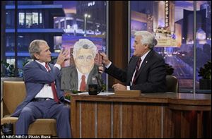 Geroge Bush on Jay Leno showing the late-night host his portrait.