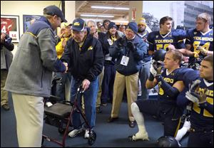 Former Toledo Rockets football coach Frank Lauterbur is applauded in the Rockets' locker room prior to the Rockets' spring game at the Glass Bowl on Friday, April 12, 2013. 