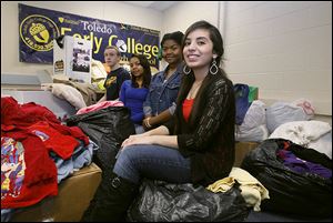 Senior class president Hala Abou-Dahech, 18; senior class secretary Carla Cunningham, 17; treasurer Patricia Jones, 18; and vice-president Matthew Wilson, 18, from right to left, rest atop the bags of clothing they have been collecting for Syrian refugees.