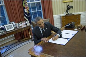President Obama signs H.R. 2747: the Streamlining Claims Processing for Federal Contractor Employees Act, Thursday in the Oval Office.