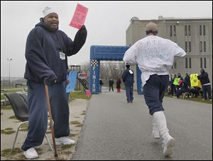 Inmate Darrell Bruce  cheers on inmates participating in the run/walk for the Komen Foundation at the prison in North Toledo.