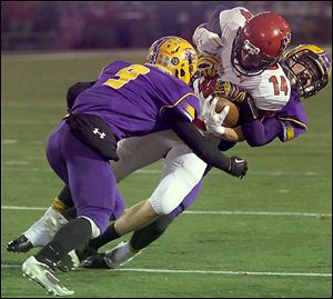 Bryan's Lucas Nye, left, and Derek Knisely take down Kenton's Luke Jackson in the second quarter.