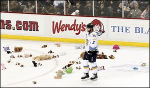 The Walleye's Joe Sova stands amidst stuffed bears that were thrown onto the ice as part of Teddy Bear Toss night on Saturday.