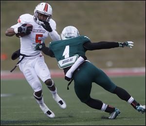 Bowling Green’s Ronnie Moore tries to slip past EMU’s Willie Creear III. Moore had seven catches for 161 yards and three scores.