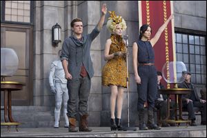 Josh Hutcherson as Peeta Mellark, left, Elizabeth Banks as Effie Trinket, and Jennifer Lawrence as Katniss Everdeen in a scene from 