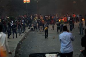 Supporters of the Muslim Brotherhood, background, throw rocks towards the security forces and those against the Muslim Brotherhood in the Nasr City district in Cairo, Egypt, Friday.