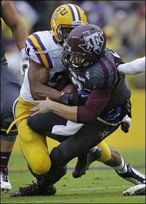 Texas A&M quarterback Johnny Manziel is tackled by LSU defensive end Danielle Hunter in the first half Saturday in Baton Rouge, La.