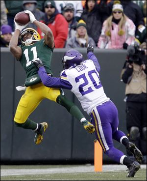 The Packers' Jarrett Boykin catches a pass in front of Minnesota Vikings cornerback Chris Cook during overtime Sunday in Green Bay, Wis. The game ended in a 26-26 tie.
