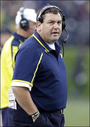 Michigan coach Brady Hoke talks on the sideline during the first half of an NCAA college football game against Northwestern in Evanston, Ill., Saturday, Nov. 16, 2013.