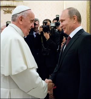 Pope Francis welcomes Russian President Vladimir Putin, right, on the occasion of their private audience at the Vatican today.