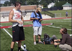 Alex Tanney, left, talks with Daniel Browning Smith, right, and a cameraman from 