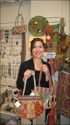 Elizabeth Zilba Baer holds fabric purses made of saris.