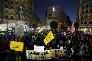 Egyptian protesters chant slogans in Talaat Harb Square in Cairo, Egypt, against the issuance of a new law regulating demonstrations today. Arabic banners read, 