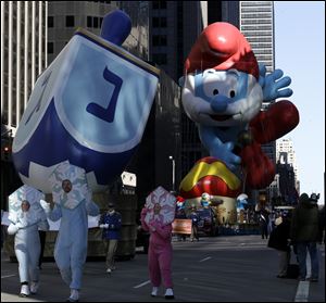 A dreidel float moves along in front of Papa Smurf during the Macy's Thanksgiving Day Parade. Hanukkah and Thanksgiving fell on the same day this year.
