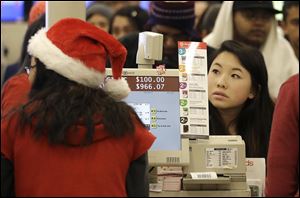 A shopper pays for her items at a cash register at a Target store in Colma, Calif., on Thanksgiving Day.