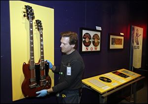 Andre Sepetavec installs a double-necked guitar in the Elvis exhibit at the Rock and Roll Hall of Fame and Museum in Cleveland. 