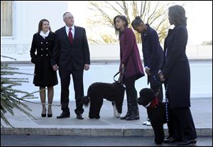 First lady Michelle Obama, right, standing with daughters Malia Obama, center, and Sasha, second from right, receive the Official White House Christmas Tree from Leslie and John Wyckoff, left, at the White House.