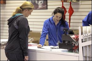 Joanna Joelson, left, of Toledo gets assistance from Libbey Glass employee Kirstin Stark at the Toledo glassmaker’s outlet store in Sylvania.
