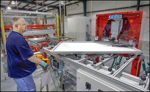 Kevin Morris uses a machine to crimp the corners of a 250 watt solar panel frame at Isofoton’s $31 million factory in Napoleon. In total, Isofoton North America garnered $8.4 million in local and state incentives.
