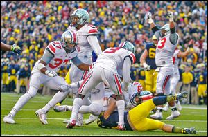 Ohio State’s Tyvis Powell (23) intercepts a pass intended for Michigan’s Drew Dileo on a two-point conversion try with 32 seconds left in the game. The Buckeyes are 12-0.