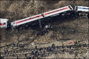 Emergency rescue personnel work the scene of a Metro-North passenger train derailment in the Bronx borough of New York today. Four people were killed and more than 60 were injured.