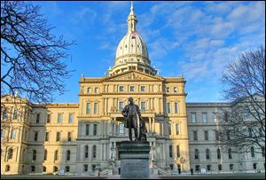 Gov. Austin Blair, the war governor (1861- 1864), is silhouetted against the Michigan state Capitol in Lansing, Mich. 