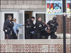 Toledo police remove an unidentified student from Scott High School after a standoff today.