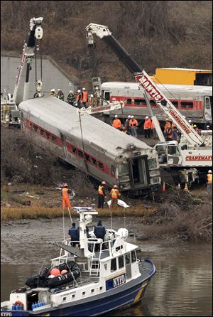 Cranes salvage the last car from from a train derailment in the Bronx section of New York on Monday.
