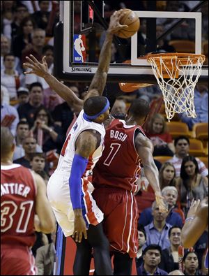 Detroit Pistons' Josh Smith (6) dunks over Miami Heat's Chris Bosh (1) during the first half.
