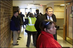 Building managers, government officials and repairmen stand in the lobby of Alpha Towers near downtown Toledo.