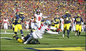 OSU quarterback Braxton Miller runs for one of his three touchdowns against Michigan on Saturday in Ann Arbor. Miller repeated as Big Ten offensive player of the year on Tuesday night.