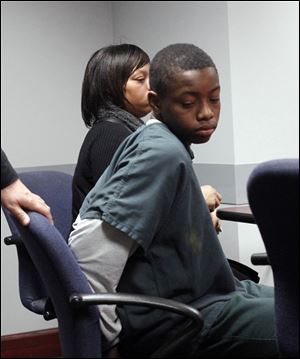 Louis Stroude, 14, right, sits with his mother Lonyel Cole, left, in the magistrates office for a hearing after Stroude took a pellet gun to Scott High School on Monday.