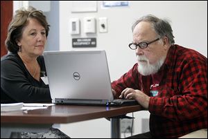 Elizabeth Macino,  a CareNet navigator, helps John Thomas of Toledo sign up for Obamacare during an initial session held on Wednesday at the United Way offices in downtown Toledo.