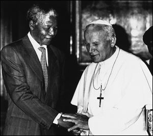 Pope John Paul II, right, shakes hands with Nelson Mandela, deputy leader of African National Congress in this 1990 photo.
