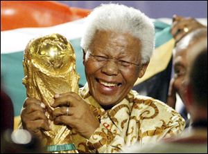 In this May 15, 2004 photo, former South African President Nelson Mandela lifts the World Cup trophy in Zurich, Switzerland, after FIFA's executive committee announced that South Africa would host the 2010 FIFA World Cup soccer tournament.
