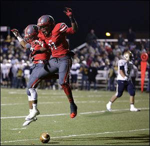 Central Catholic WR Jermiah Braswell (11) celebrates scoring a touchdown against Tiffin Columbian with teammate Marcus Winters (5) during the Division III Regional Semifinal football game Friday, Nov. 15, 2013, in Fremont.