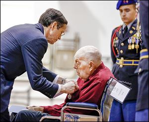 French Consul Stephen Knerly, Jr., awards John Stauffer, 91, the Medal of Knight of the Legion of Honor — France’s highest award — at the Ohio Veterans Home. Mr. Stauffer was wounded at Normandy in World War II.