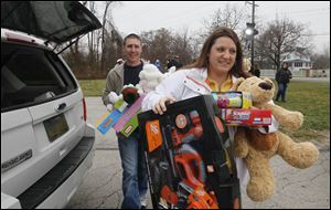 Ben and Tiffany Decker of Maumee carry toys to the WTVG-TV toy drive.
