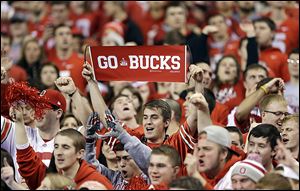 Ohio State fans cheer before the Big Ten championship game between Ohio State and Michigan State in Indianapolis. OSU fans filled about 75 percent of the stadium on Saturday.