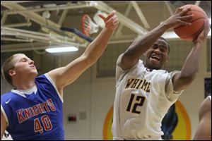 Whitmer's sophomore Kemontrece Collins (12) pulls down a rebound over St. Francis' junior Jacob Lang (40) during the first quarter of the Friday, Dec. 6, 2013, matchup at Whitmer. Whitmer won, 54-50.