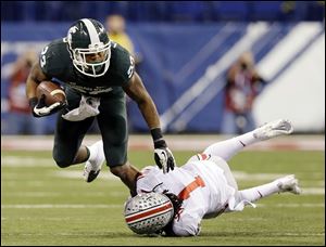 Michigan State's Jeremy Langford, left, is tackled by Ohio State's Bradley Roby (1) during the Big Ten  championship game.