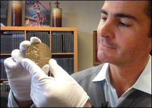 Dan Imler of SCP Auctions shows Jessie Owens gold medal from the 1936 Olympics at the SCP Auctions in Laguna Nigel, Calif. 