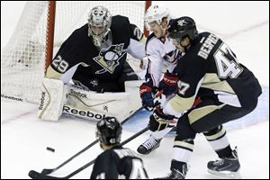 Columbus Blue Jackets center Boone Jenner, center, can't get a shot off between Pittsburgh Penguins goalie Marc-Andre Fleury (29) and Pittsburgh Penguins' Simon Despres (47) in the first period.