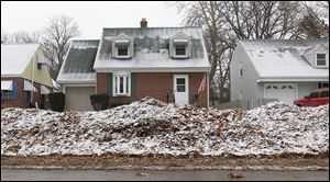 Leaves are piled along the curb in front of some of the homes on Beverly Drive in South Toledo.