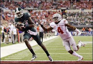 Michigan State's Tony Lippett, left, makes a 33-yard touchdown reception against Ohio State's C.J. Barnett (4) during the first half of a Big Ten Conference championship NCAA college football game Saturday, Dec. 7, 2013.