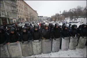 Ukrainian riot police block the road next to Pro-European Union activists gathered on the Independence Square in Kiev, Ukraine today.